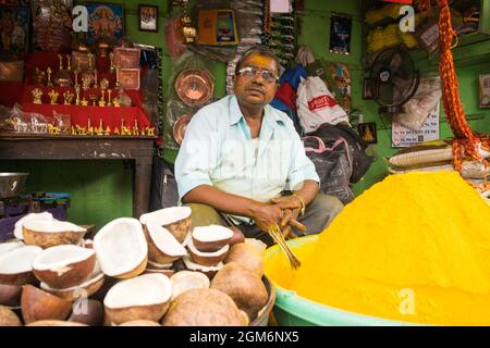 Un negoziante che vende articoli di puja fuori dal famoso e bellissimo tempio di Khandoba a Jejuri durante il festival di Somvati Amavasya Foto Stock