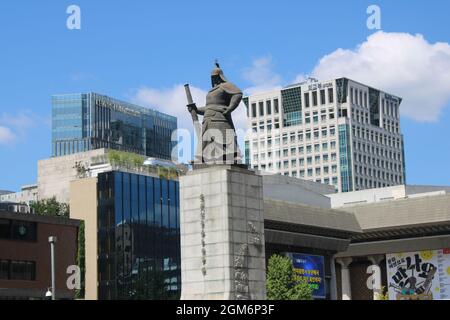 Monumento commemorativo dell'ammiraglio Yi Sun-sin in piedi in piazza Gwanghwamun, circondato da edifici e traffico, a Seoul, Corea Foto Stock