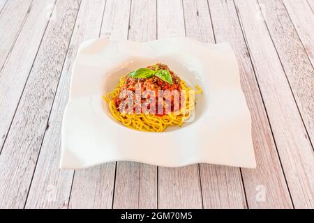 Ricetta per spaghetti con carne tritata cotta con salsa di bolognese su piatto bianco Foto Stock