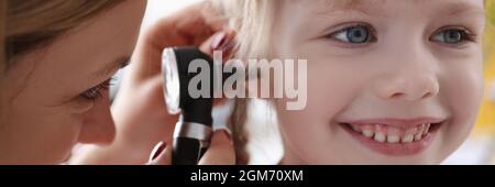 ENT medico che esamina l'orecchio irritato di bambino piccolo usando otoscopio Foto Stock