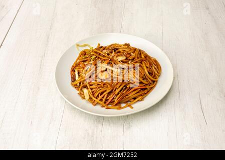 Ricetta tagliatelle cotte tre prelibatezze e salsa yakitori saltato con verdure e carote e semi di sesamo su piatto bianco Foto Stock