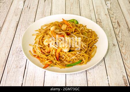 Noodle in wok cinese con gamberi cotti, verdure e germogli di fagioli in un ristorante cinese Foto Stock