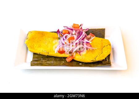 Mais masa tamale farcito con carne di pollo stufata con cipolla viola cruda e pomodoro fresco a dadini Foto Stock