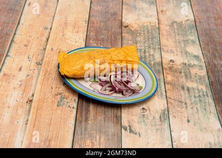 Vassoio molto colorato con tamale ripieno di carne di pollo con ricetta messicana con cipolla viola e coriandolo Foto Stock