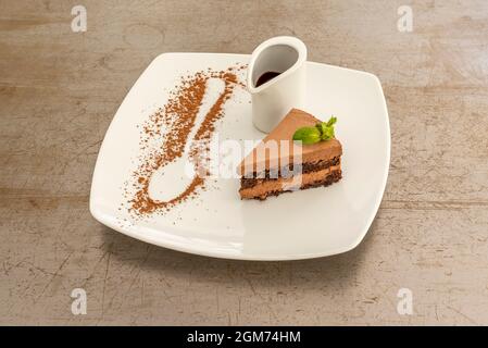 Razione di torta al cioccolato con pan di Spagna e mousse e succo di cioccolato in una ciotola bianca Foto Stock