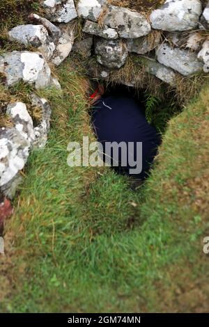 Sud-terreno sull'isola di Cannon esplorato da un uomo che indossa una torcia da testa Foto Stock