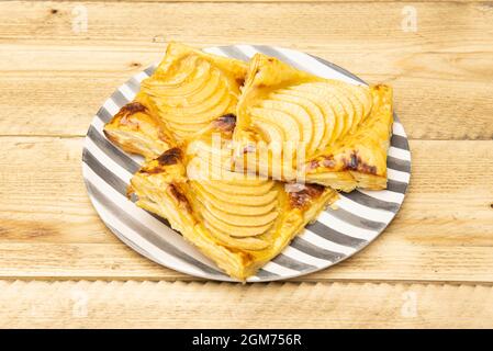 Piatto con deliziose tartine di mele con caramello su tavola di legno Foto Stock