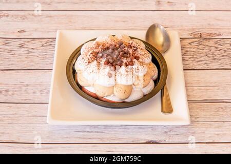 Torta ghiacciata tiramisù fantasy con cucchiaio su piatto bianco Foto Stock