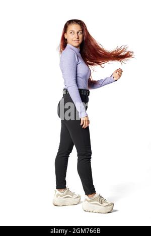 La giovane donna caucasica gioca con i capelli che galleggiano su un isolato sfondo bianco in studio Foto Stock