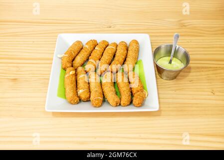 Tipico venezuelano tequeños ripieno di formaggio e fritto in olio d'oliva con salsa di immersione Foto Stock