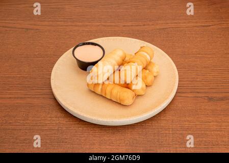 Tipico tequeños venezuelano fritto con prosciutto e formaggio per colazione con un caffè Foto Stock