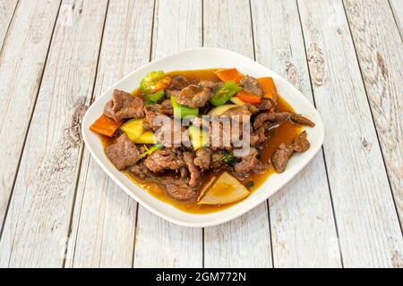 Ricetta cinese per manzo con verdure saltate. Pezzi di cipolla, zucchine e salsa di soia Foto Stock