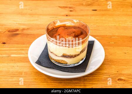 Dessert al tiramisù con molta polvere di cacao all'interno di un bicchiere di cristallo servito in un ristorante italiano Foto Stock