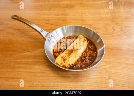 Frittata francese con trippa di merluzzo servita in una padella metallica Foto Stock