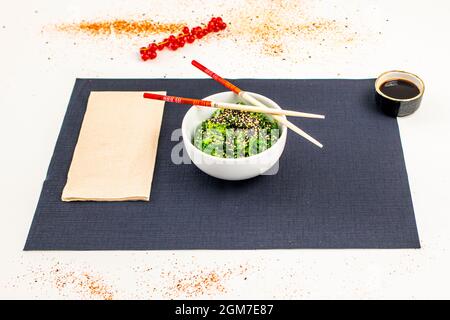 Insalata giapponese di alghe di wakame con semi di sesamo, fagioli di soia e bacchette Foto Stock
