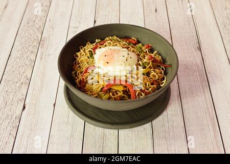 Pasta asiatica con sesamo, peperoni fritti saltati e uova fritte sopra Foto Stock