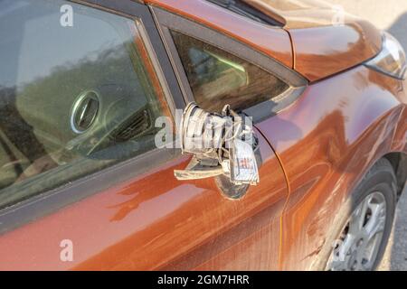 Specchietto laterale rotto su auto sporca. Specchietto retrovisore esterno destro danneggiato in primo piano Foto Stock