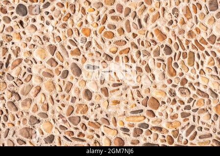 Cornice con una moltitudine di piccole rocce fluviali lucide di diversi colori che attraversano l'intero spettro. Struttura vettoriale di pietre sfondo Foto Stock