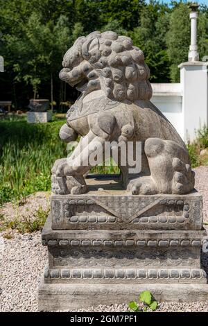 JÖNSTORP, SVEZIA - 18 LUGLIO 2021: Una statua di un leone cinese seduto al santuario yangtorp di Skåne. Foto Stock