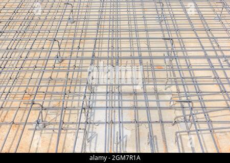 Barre di acciaio per cemento armato per formare una gabbia di rinforzo solida e livellata in preparazione alla colata di calcestruzzo all'interno della forma. Foto Stock