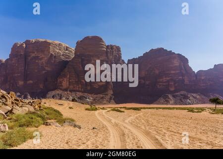 Montagne rosse del deserto di Wadi Rum in Giordania. Wadi Rum, conosciuta anche come la Valle della Luna, è una valle tagliata nella pietra arenaria e granito a sud Foto Stock
