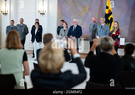 17 settembre 2021, Berlino: Il generale Brigadier Jens Arlt (indietro, 2° da destra), comandante dell'operazione di evacuazione militare dall'Afghanistan, sua moglie Sonja (alla sua destra), il presidente federale Frank-Walter Steinmeier e sua moglie Elke Büdenbender (entrambe indietro, centro) e Annegret Kramp-Karrenbauer (indietro, 3° da sinistra, CDU), Ministro della difesa, Stand con i soldati dopo aver assegnato al comandante la prima Croce di Classe dell'Ordine del merito della Repubblica federale di Germania a Bellevue Palace. Con il premio, il presidente federale vuole rendere omaggio a nome di tutti i soldati coinvolti nella ev Foto Stock