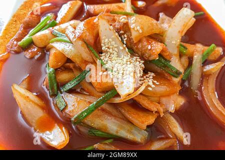 Delizioso tteokbokki piccante coreano. L'immagine di tteokbokki piccante su sfondo di legno Foto Stock