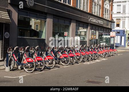 Una docking station di Santander su Limerston Street fuori dal Pizza Express, fuori da Fulham Road, Chelsea, Inghilterra, Regno Unito Foto Stock