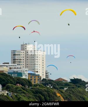 Bournemouth, Dorset, Regno Unito. 17 settembre 2021. Meteo Regno Unito. I parapendio riempiono il cielo mentre volano sopra le scogliere sopra la spiaggia di Bournemouth a Dorset in una giornata di caldo e nocciola sole autunnale. Picture Credit: Graham Hunt/Alamy Live News Foto Stock