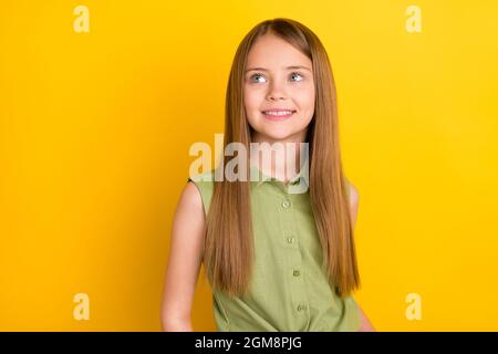 Foto ritratto scolgirl indossare camicia verde guardando copyspace sognante isolato giallo brillante sfondo di colore giallo Foto Stock