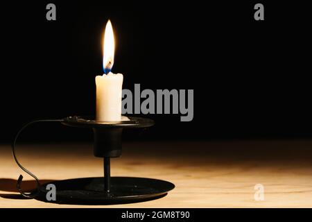 Bellissimo sfondo nero con una candela illuminata Foto Stock