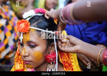 Mongla, Bangladesh. 11 Settembre 2021. Un parente aiuta a regolare gli ornamenti di 14 anni di scuola andare ragazza Hafsa il suo giorno di nozze in un villaggio di nome Joymoni da una zona costiera di Mongla nel distretto di Bagerhat.Bangladesh ha assistito ad un aumento del 13% nei matrimoni infantili durante la pandemia di Covid-19 l'anno scorso come il virus mortale massicciamente le società e le economie colpite, spingendo molte verso l’estrema povertà. Il dipartimento per la giustizia e la diversità di genere di Brac, la più grande ONG del mondo, ha riscontrato che il matrimonio minorile è aumentato del 13% quando ha condotto un sondaggio per accedere all'impatto del panda Covid-19 Foto Stock