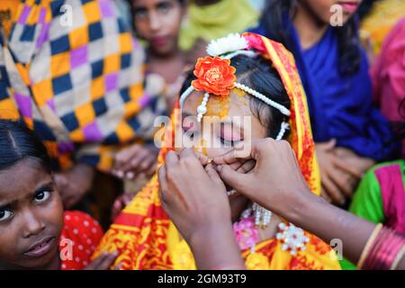 Mongla, Bangladesh. 11 Settembre 2021. Un parente aiuta a regolare gli ornamenti di 14 anni di scuola andare ragazza Hafsa il suo giorno di nozze in un villaggio di nome Joymoni da una zona costiera di Mongla nel distretto di Bagerhat.Bangladesh ha assistito ad un aumento del 13% nei matrimoni infantili durante la pandemia di Covid-19 l'anno scorso come il virus mortale massicciamente le società e le economie colpite, spingendo molte verso l’estrema povertà. Il dipartimento per la giustizia e la diversità di genere di Brac, la più grande ONG del mondo, ha riscontrato che il matrimonio minorile è aumentato del 13% quando ha condotto un sondaggio per accedere all'impatto del panda Covid-19 Foto Stock