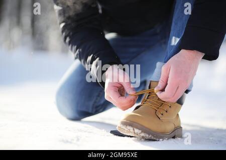 Passi lungo il sentiero innevato. Un uomo cammina nel parco in inverno. Foto Stock