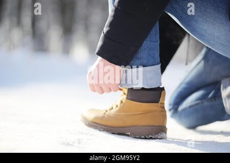 Passi lungo il sentiero innevato. Un uomo cammina nel parco in inverno. Foto Stock