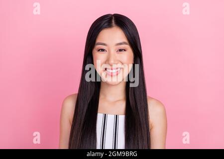 Foto della millenaria bruna donna ottimista indossare bianco tuta isolato su sfondo rosa Foto Stock