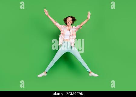 Pieno corpo foto di allegro positivo felice giovane donna salto in forma stella vendita sogno isolato su sfondo verde colore Foto Stock