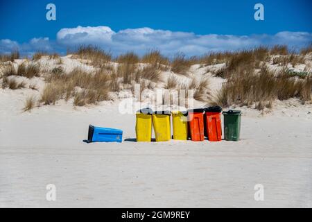 contenitori di rifiuti in vari colori sulla spiaggia, per preservare la spiaggia pulita dai rifiuti Foto Stock