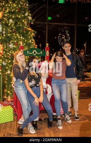 12 15 2018 Tulsa USA Gruppo di adolescenti posare con Babbo Natale di fronte all'albero di Natale al Williams Lodge al luogo di raccolta parco pubblico Foto Stock