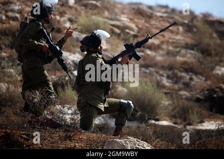Nablus, Palestina. 17 settembre 2021. Un soldato israeliano punta il suo fucile contro i manifestanti. I palestinesi hanno tenuto una manifestazione contro la creazione di un avamposto ebraico nel villaggio di Beit Dajan, ad est della città di Nablus in Cisgiordania. (Foto di Nasser Ishtayeh/SOPA Images/Sipa USA) Credit: Sipa USA/Alamy Live News Foto Stock