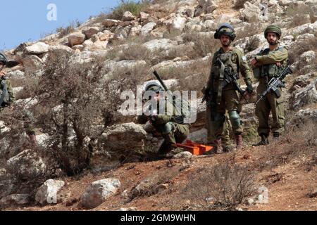 Nablus, Palestina. 17 settembre 2021. Un soldato israeliano punta il suo fucile contro i manifestanti. I palestinesi hanno tenuto una manifestazione contro la creazione di un avamposto ebraico nel villaggio di Beit Dajan, ad est della città di Nablus in Cisgiordania. (Foto di Nasser Ishtayeh/SOPA Images/Sipa USA) Credit: Sipa USA/Alamy Live News Foto Stock