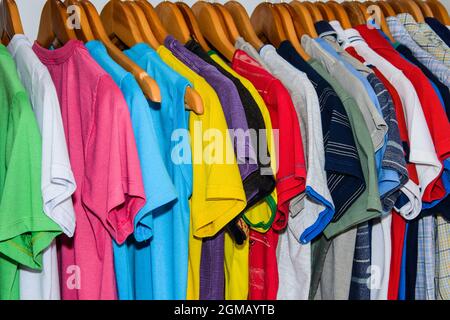 Un sacco di camicie colorate sull'appendiabiti ordinate e lavate per l'uso. Salvador Bahia Brasile. Foto Stock