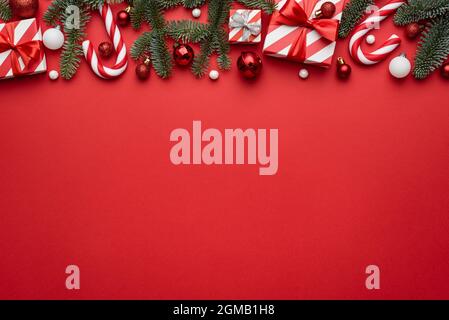 Sfondo rosso di Natale con bordo decorato con regali di festa e canne caramelle Foto Stock