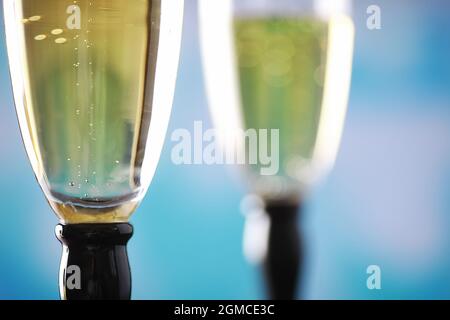 Fondo con bicchieri alti per spumanti. Champagne spray in bicchieri di vetro. Bevanda celebrativa con riflessione. Foto Stock