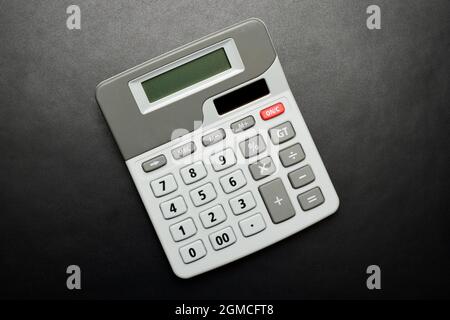 Vista dall'alto della calcolatrice su sfondo nero texture, Foto Stock