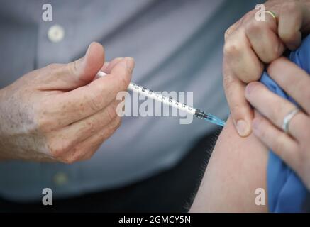 Foto del fascicolo del 21/12/20 di una persona che riceve il vaccino Pfizer-BioNTech presso un centro di vaccinazione di York. Secondo i ricercatori, gli anziani, gli uomini e coloro che hanno origini etniche hanno maggiori probabilità di finire in ospedale o morire anche dopo essere stati vaccinati contro il Covid-19. Data di emissione: Sabato 18 settembre 2021. Foto Stock