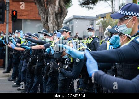 Melbourne, Australia. 18 settembre 2021. Un poliziotto si ritorma dopo essere stato colpito in faccia con una bottiglia di latte. Credit: Jay Kogler/Alamy Live News Foto Stock