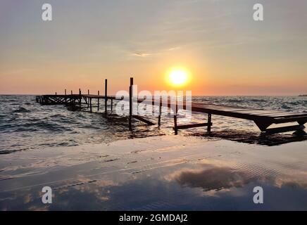 Bellissimo molo di pesca in legno al tramonto sul mare Foto Stock