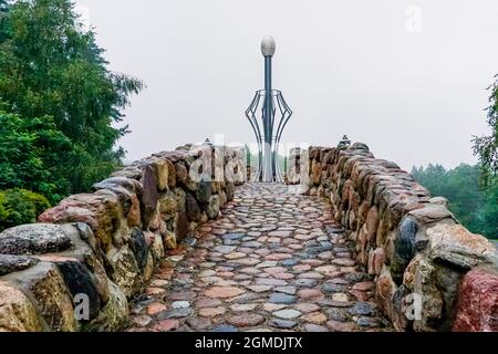 Merkine, Lituania - 31 agosto 2021: Sentiero in pietra che conduce a una statua della fede e dell'energia del New Age nella Piramide dei Giardini Merkine Foto Stock