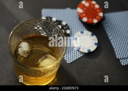 Gioco d'azzardo Giochi di carte per soldi. Texas Hold'em Poker. Carte in mano, giocare chip, mazzo di carte di alcol in un bicchiere. Foto Stock